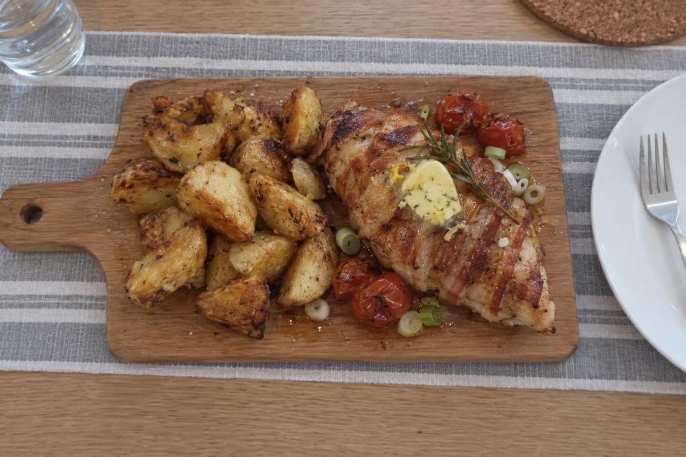 Bacon-wrapped chicken breast with roast potatoes and lemon butter