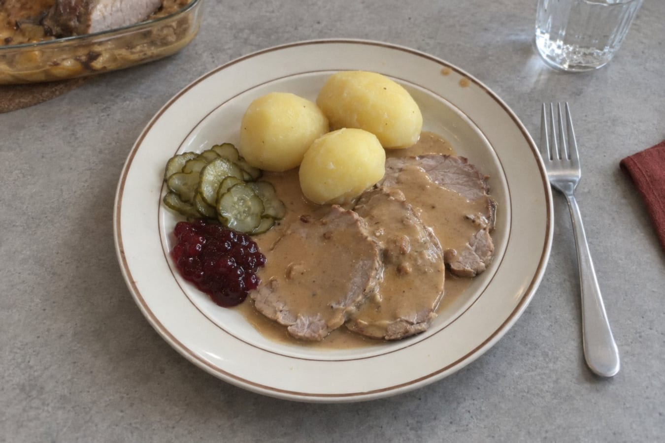Asado de ternera brasado con salsa de crema, papas y pepinillos