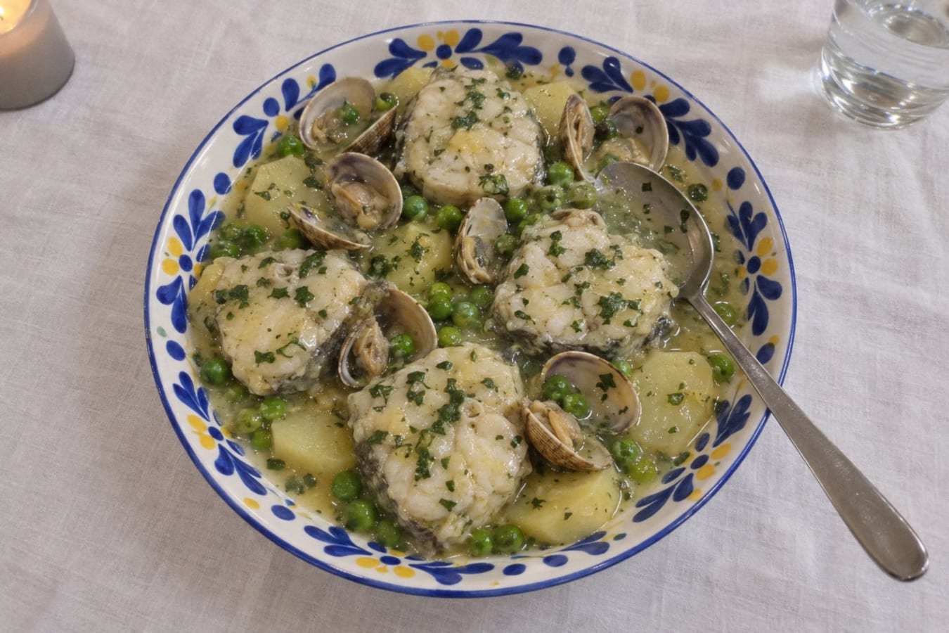 Hake in green parsley sauce with clams and potatoes