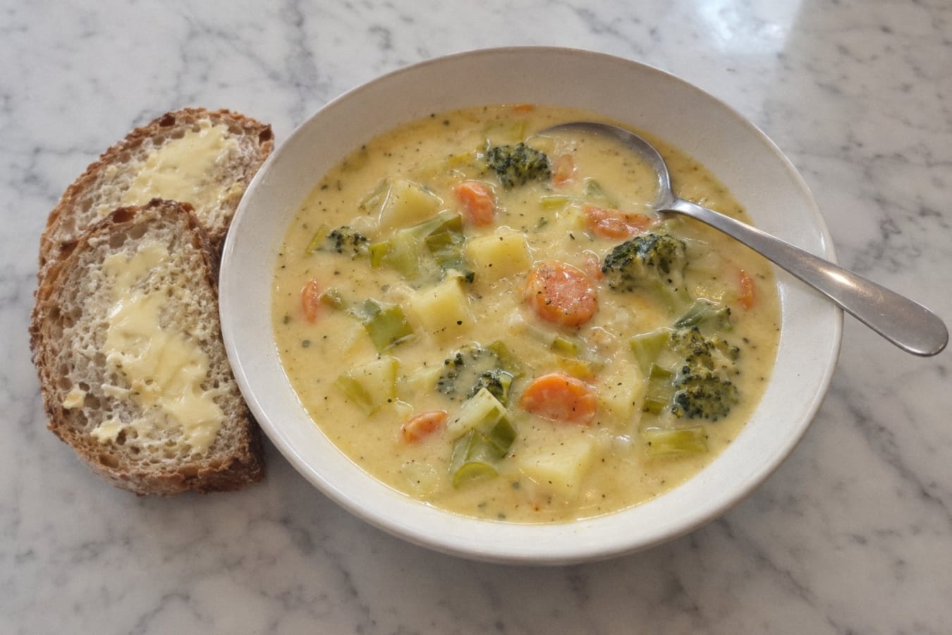 Sopa de queso con verduras y pan con mantequilla