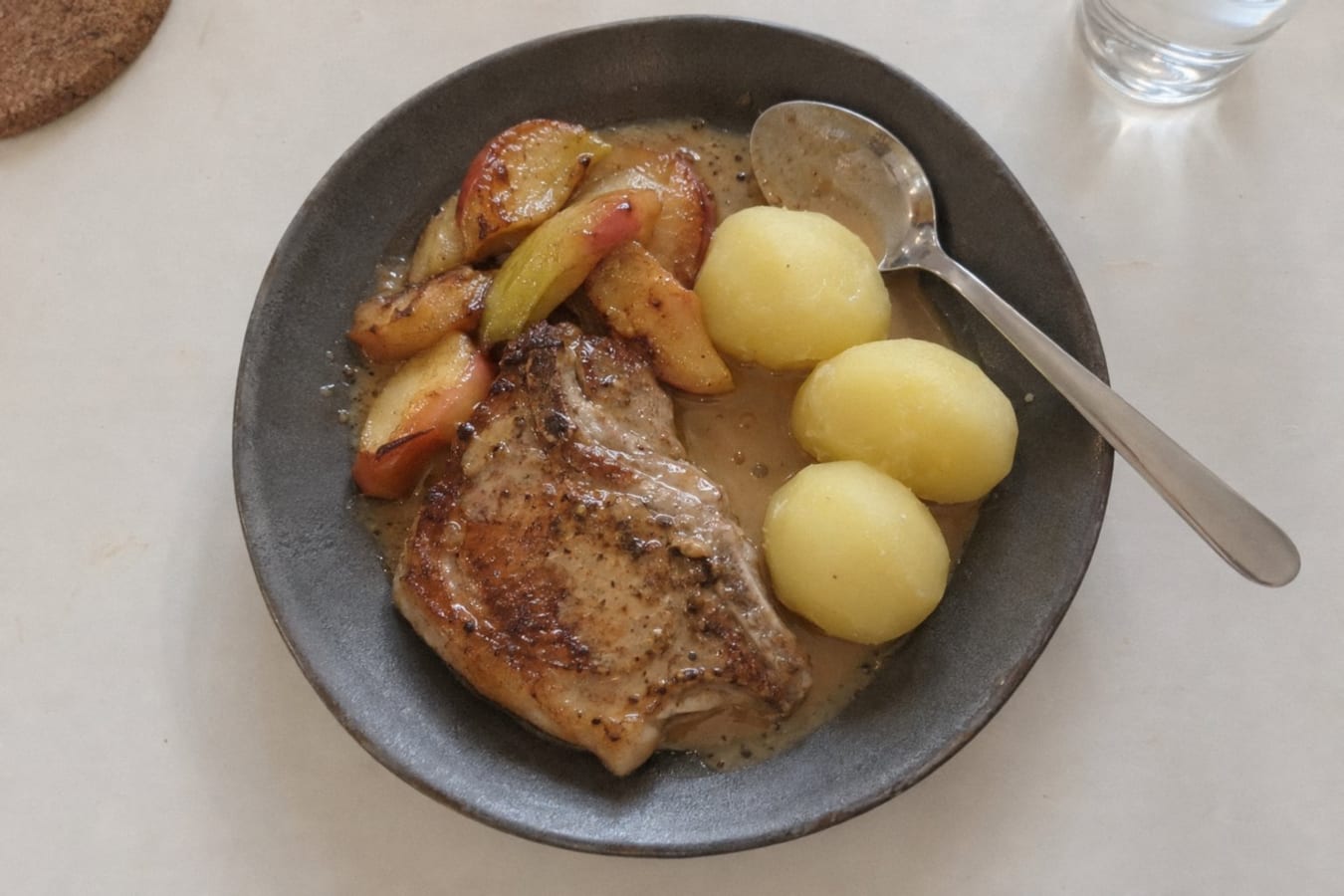 Chuletas de cerdo con manzanas salteadas, salsa de crema y papas