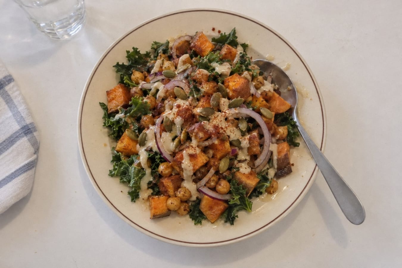 Batata asada con garbanzos, kale y aderezo de tahini